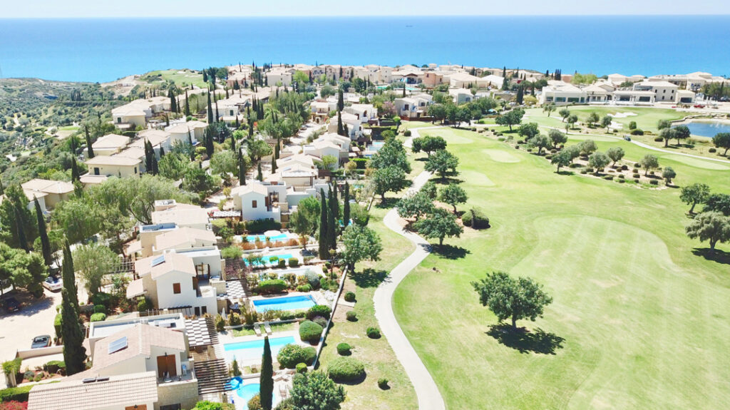 View of Hestaides Greens Village communal pool on Aphrodite Hills Resort, Cyprus, with golf and sea views.
