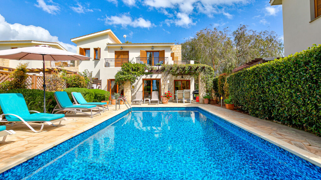 Looking at the back of Villa HG28 overlooking the pool and poolside terrace with sun loungers. Aphrodite Hills Resort Cyprus.