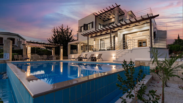 View of Villa 262 Demeter's pool and back terraces lit up at twilight, Aphrodite Hills Resort, Cyprus. Presented by Aphroditerentals.com